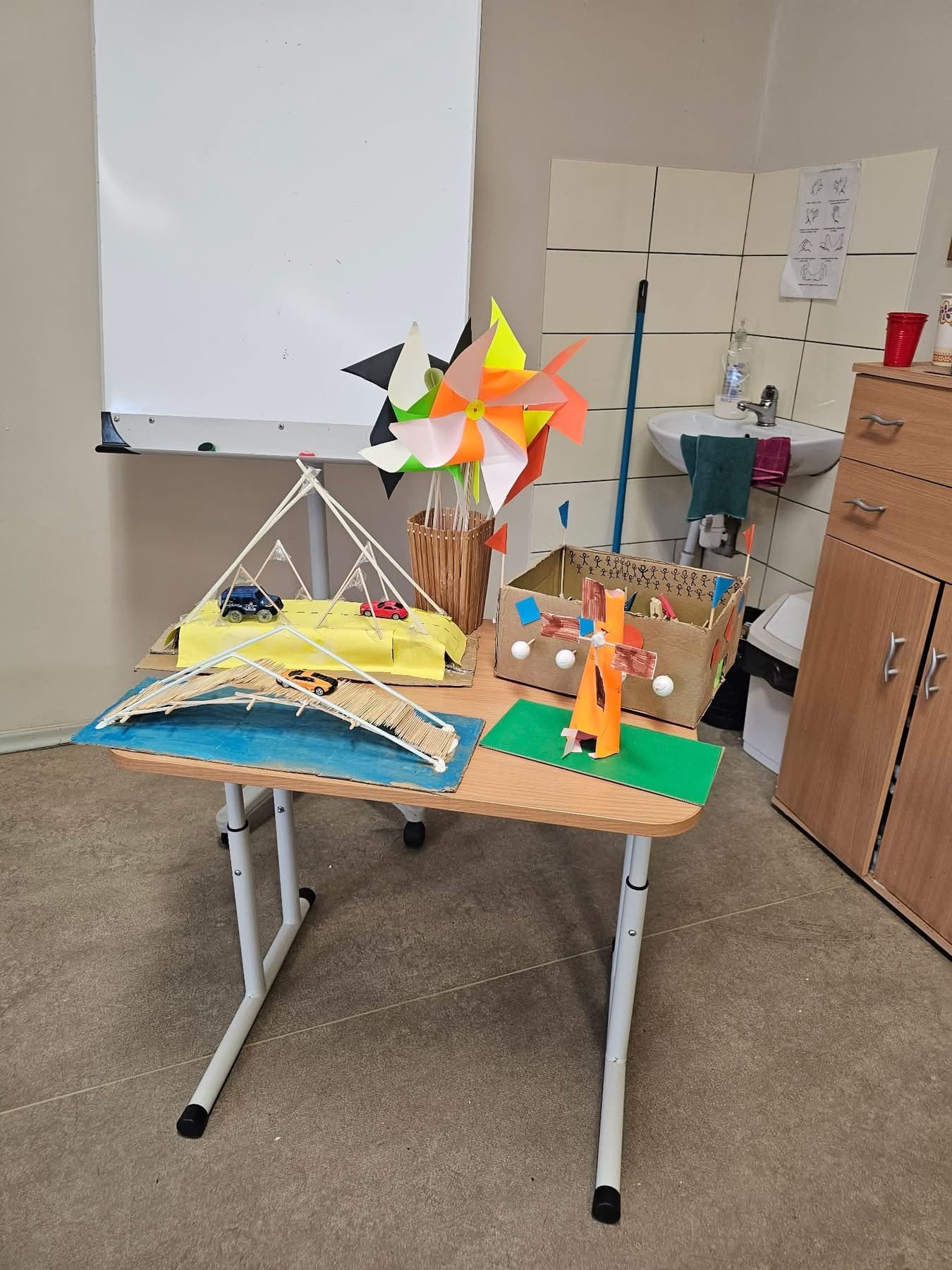 Student project display with bridge model and pinwheel